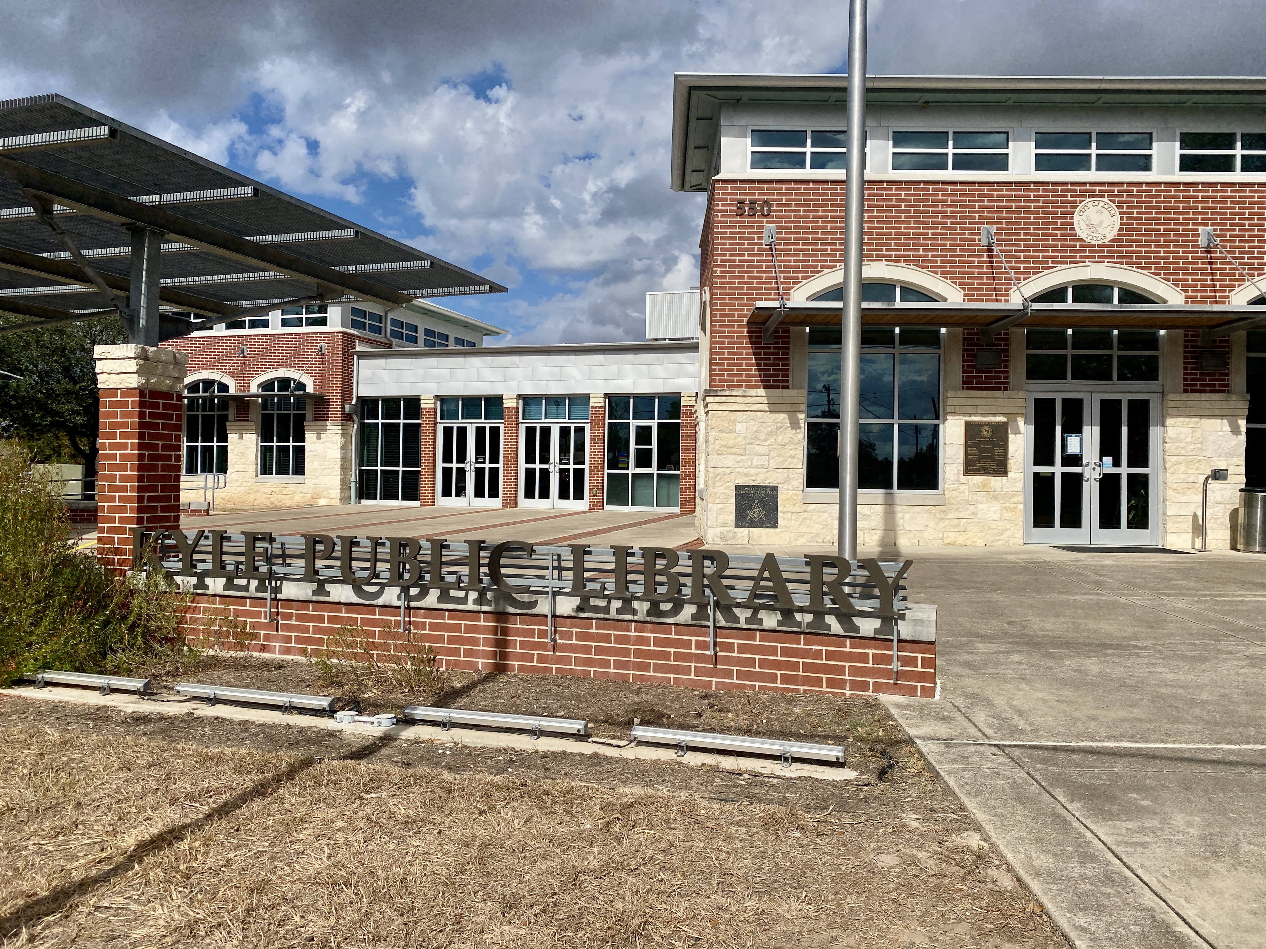 The entrance to Kyle Public Library with its large outdoor sign.