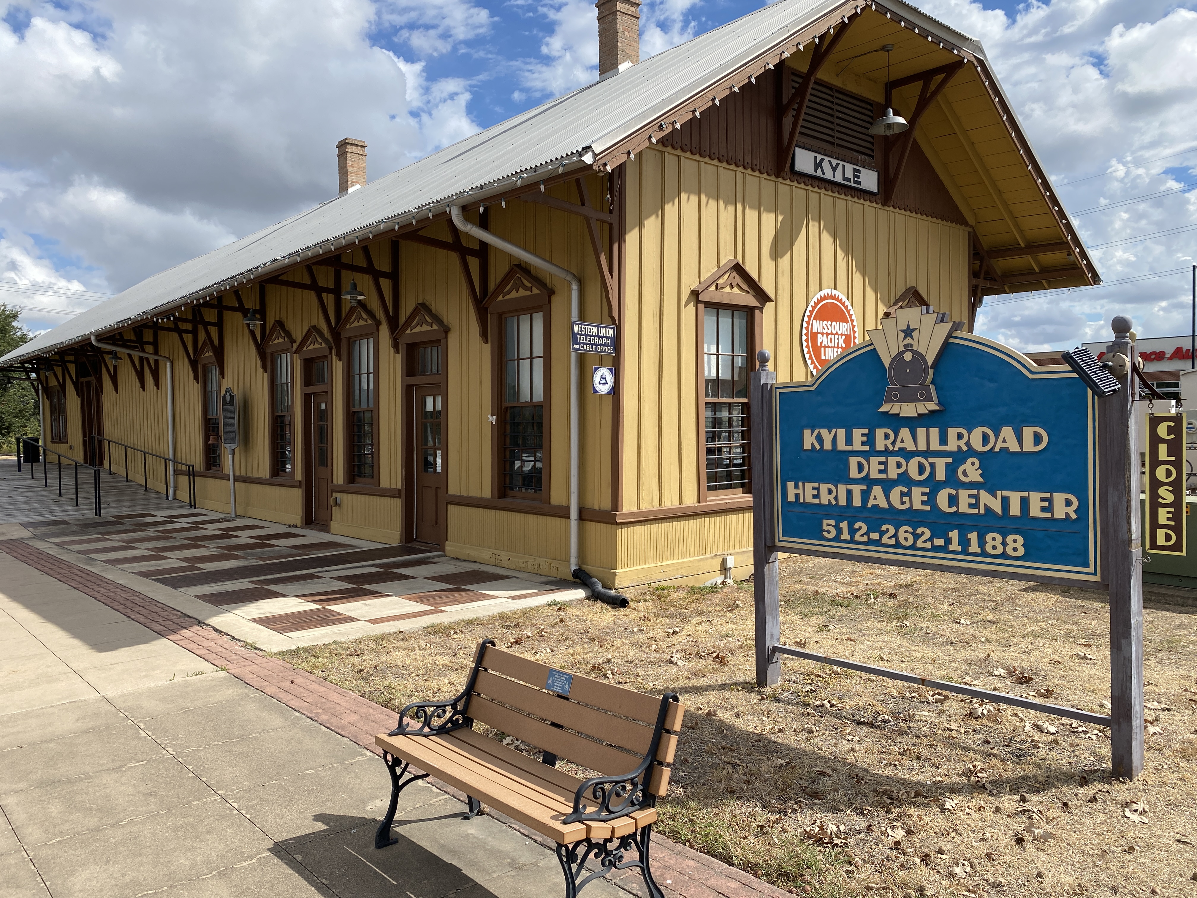 The yellow Kyle Railroad Depot and Heritage Center with its blue entrance sign.